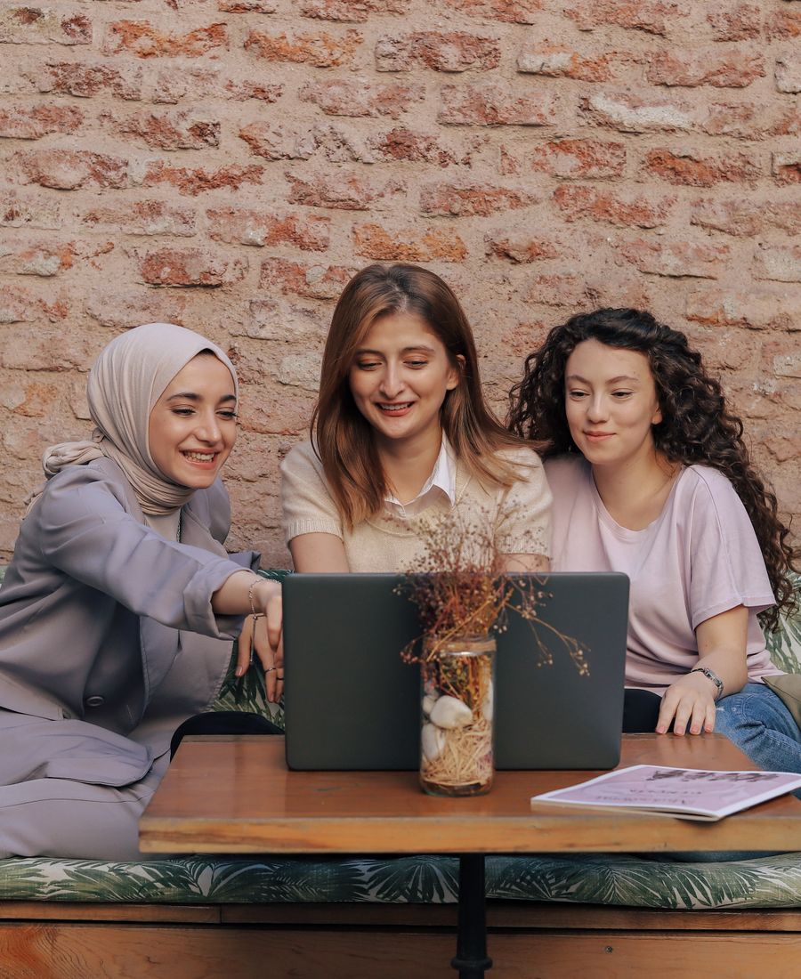 Laptop başında sohbet eden üç arkadaş