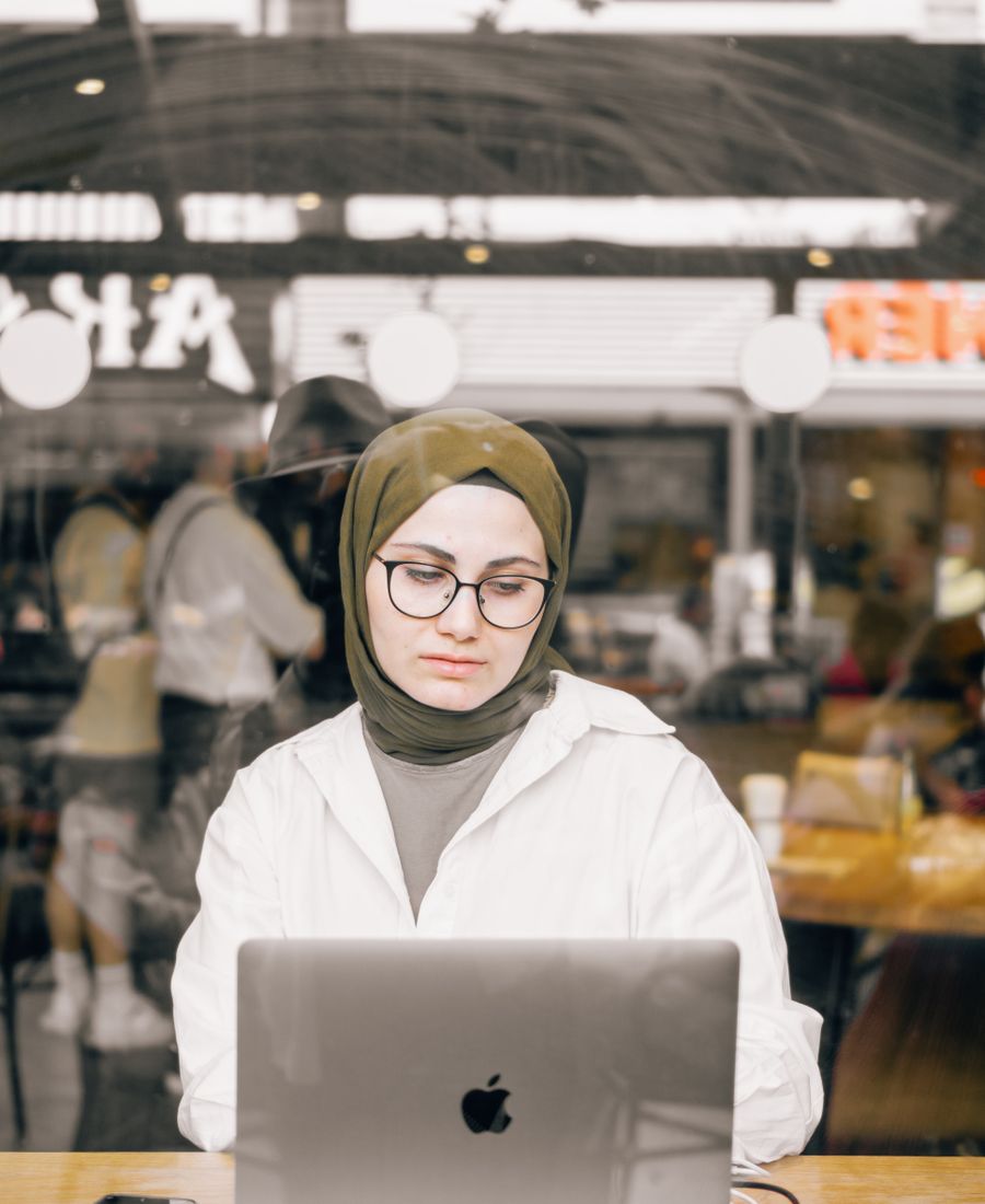 Kafede laptopla derse katılan bir öğrenci