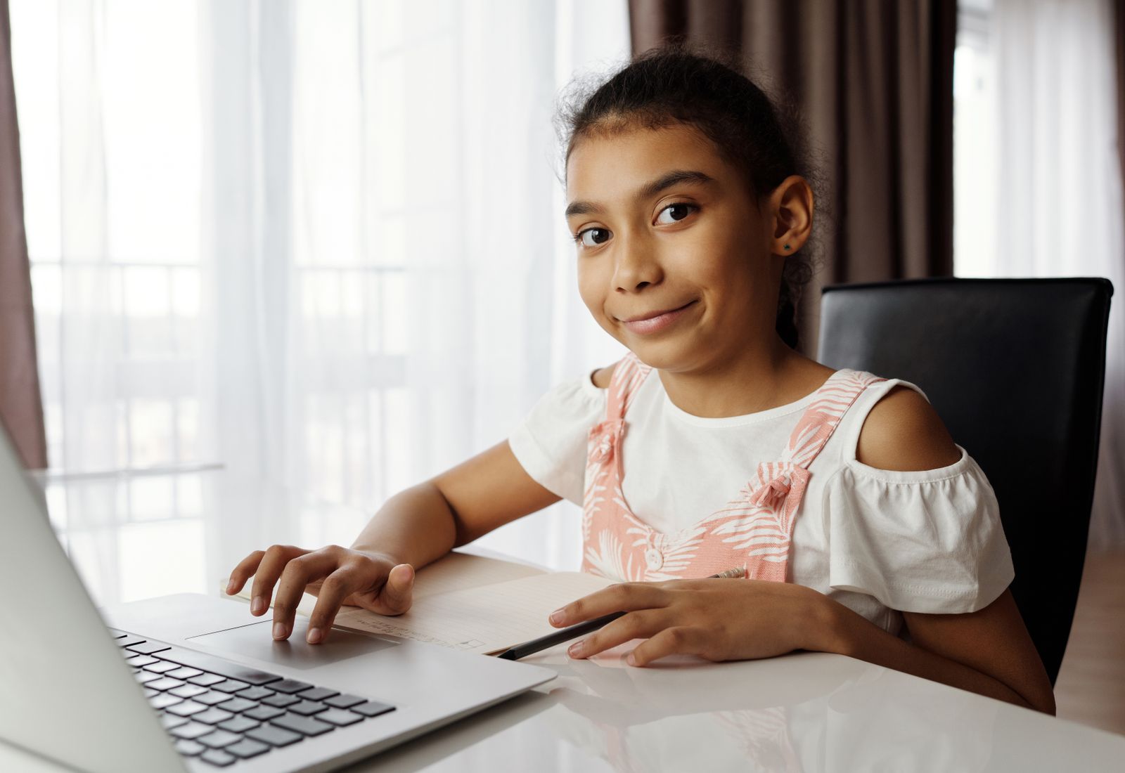 Online İngilizce dersinde gülümseyen bir kız çocuğu